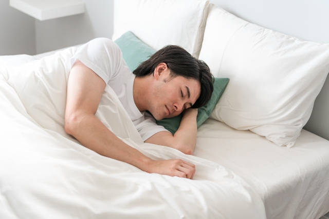 横向きに眠る男性の画像