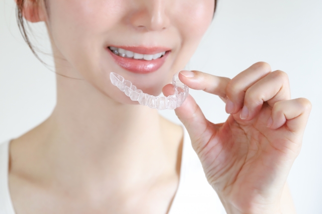 いびき改善に使われるマウスピース型矯正装置を手に持つ女性の画像