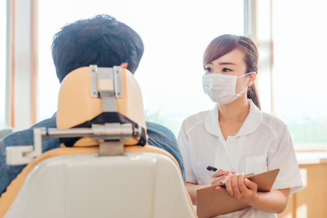 足利市の歯科医院でスタッフが患者に聞き取りをしている様子のイメージ画像