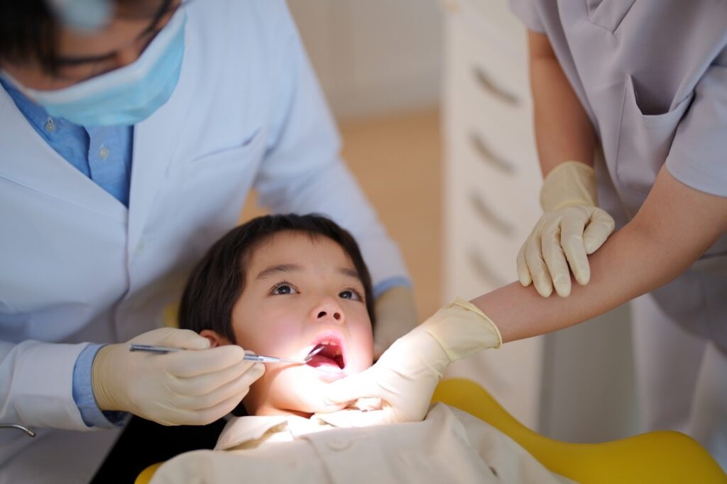 子どもの矯正治療のタイミングを確認する歯科スタッフの画像