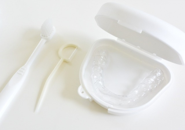 リテーナーと歯ブラシやフロスなどの清掃道具の画像