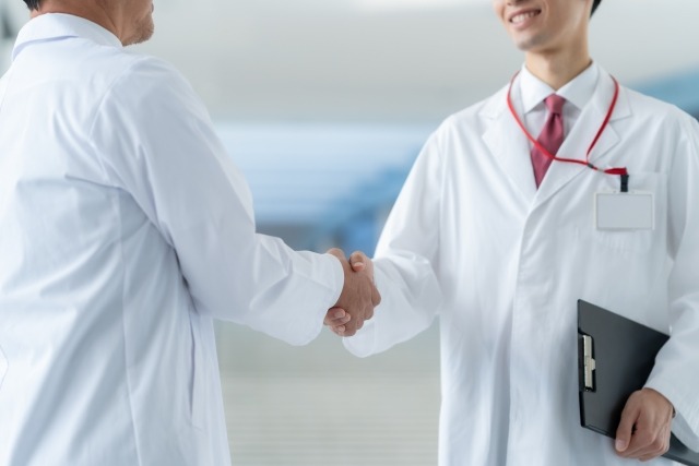 矯正歯科医と一般歯科医が握手をして連携をとっているイメージ画像