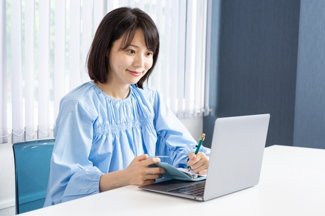 矯正費用をパソコンで確認している女性のイメージ画像