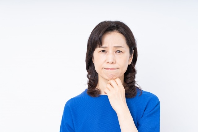 歯列矯正を受けるか悩んでいる50代女性の画像