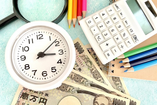矯正治療にかかる期間と費用を想起する、電卓と時計の画像