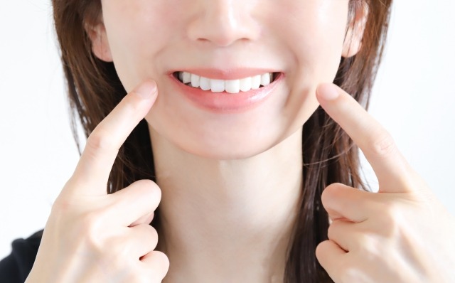 口元を指差す女性