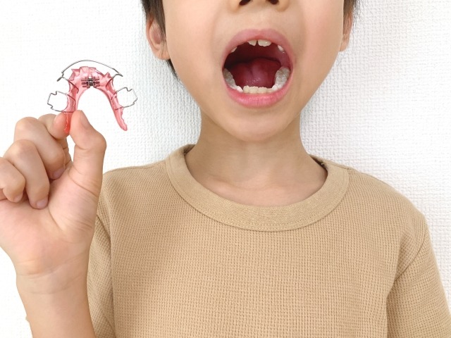 矯正器具を手に持つ子ども